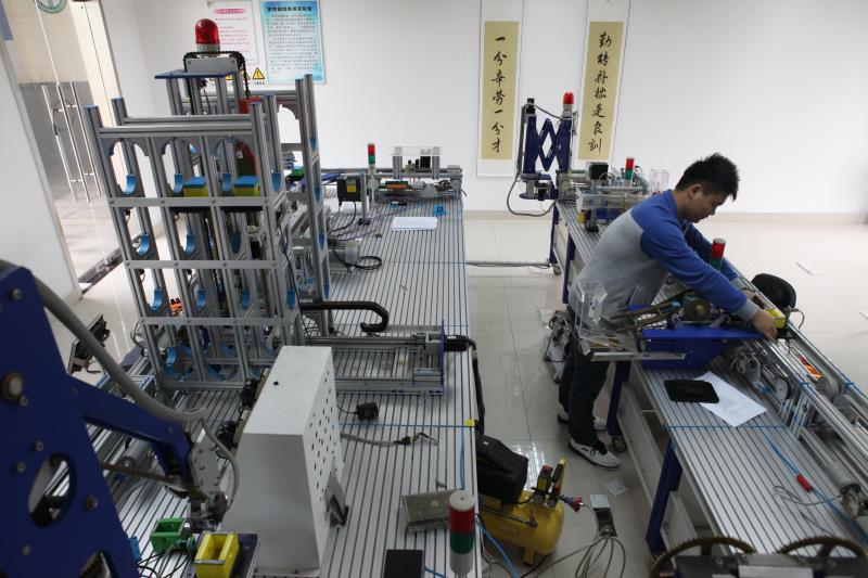 学校与龙头企业合作,引入华为、中兴等企业的知识体系,在校内设立建制班级或开设相关课程。图为学生在先进自动化技术联合示范实验中心学习。